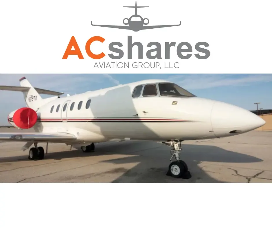 A white business jet with a red engine cover on the left engine, tail number N89TK, parked on an tarmac under a blue sky.