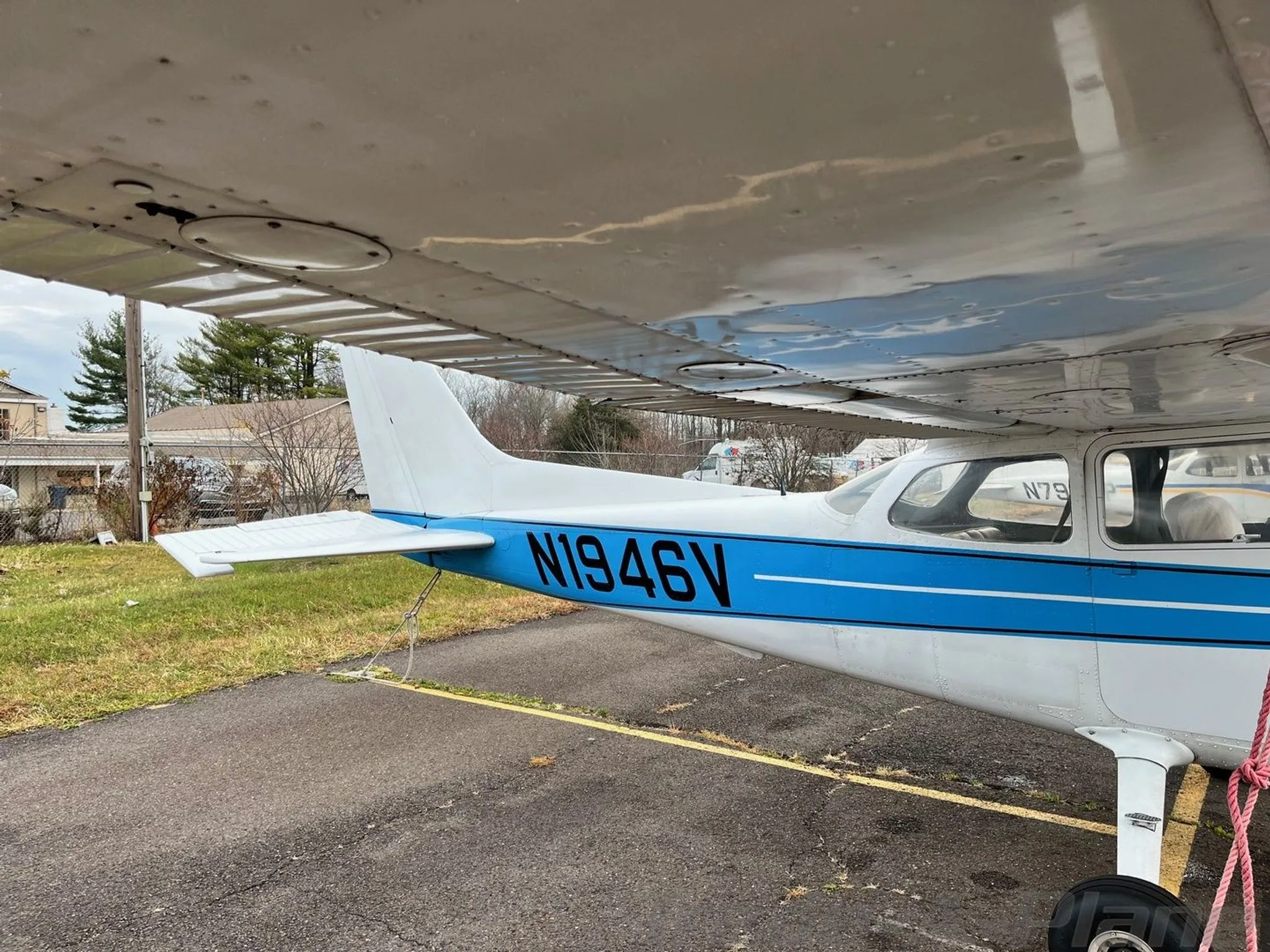 A view of the underside of the wing and the rear fuselage of the N1946V aircraft, showing the blue stripe.