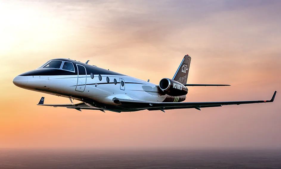A Cessna Citation CJ3+ in flight against a colorful sky.