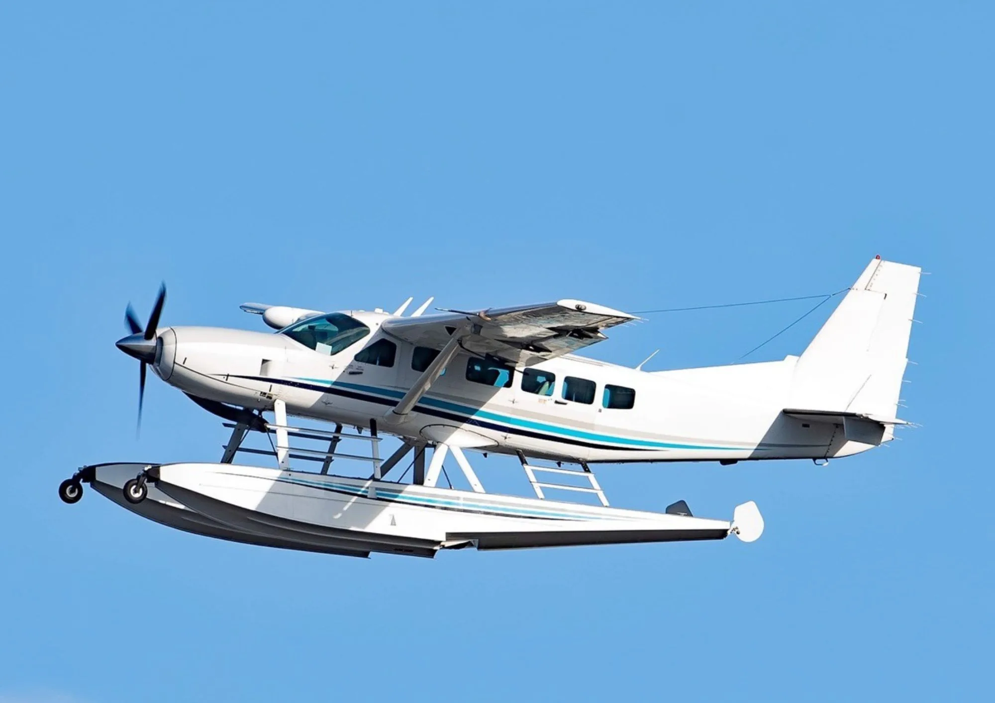 A seaplane in flight against a clear blue sky.