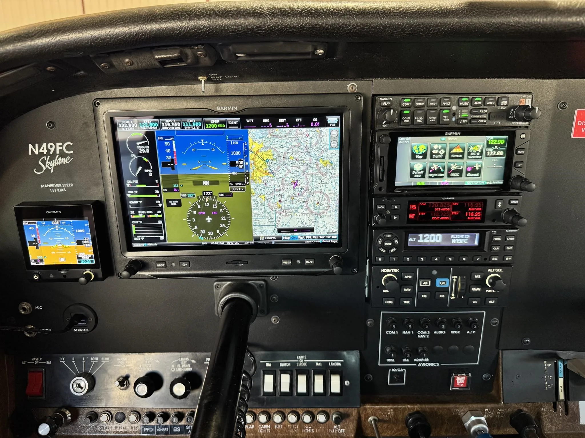 A close-up view of the Cessna N49FC cockpit, showing the Garmin G1000 NXi glass panel and other instruments.