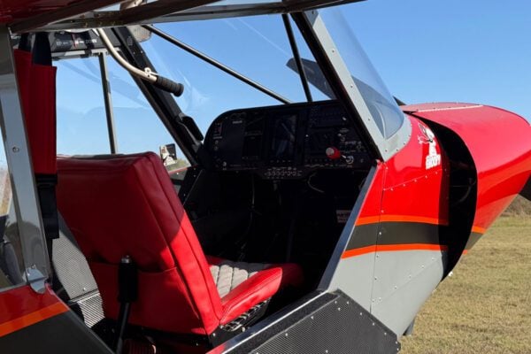 View of the cockpit with red seat and instrument panel.