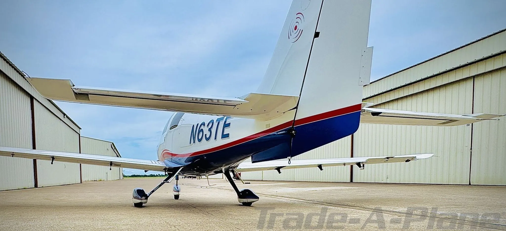 Rear view of a white and blue Columbia 400, showing the N63TE registration on the fuselage.
