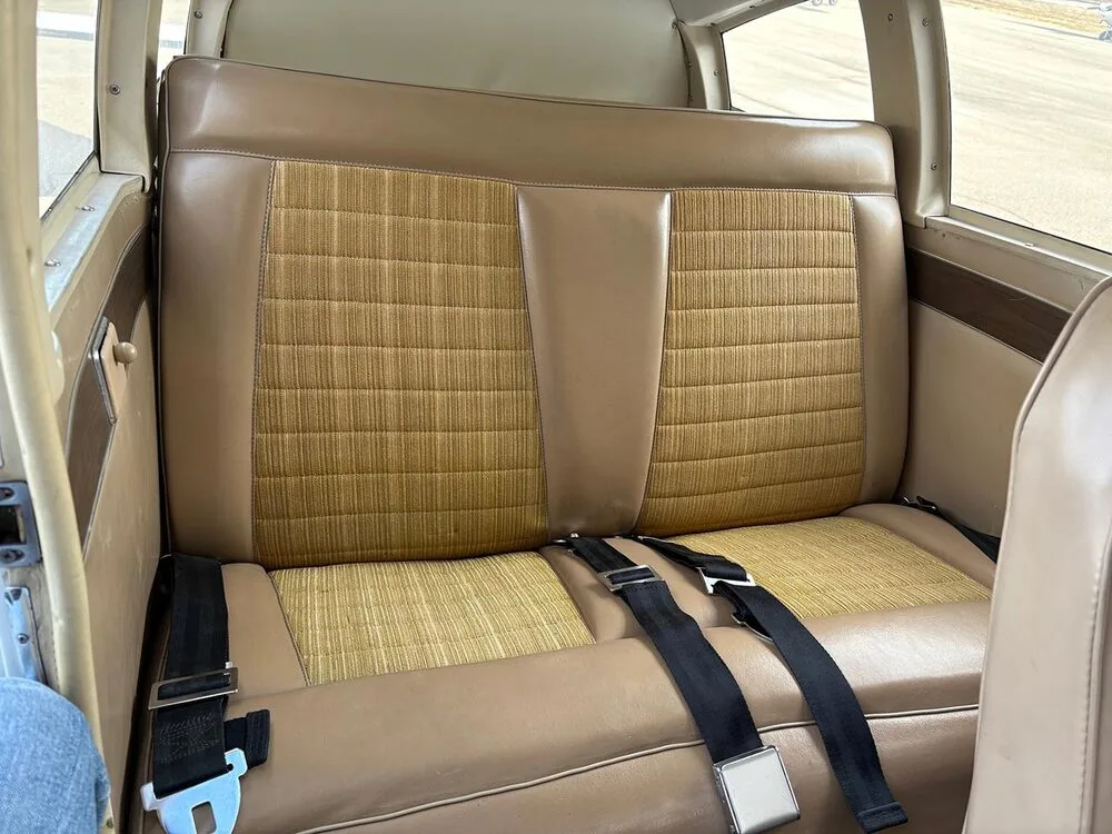 The tan and patterned rear passenger seats of the aircraft cabin.