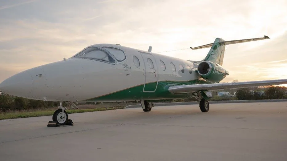 Beechcraft Premier 400A aircraft parked on the tarmac with a green and white paint scheme.