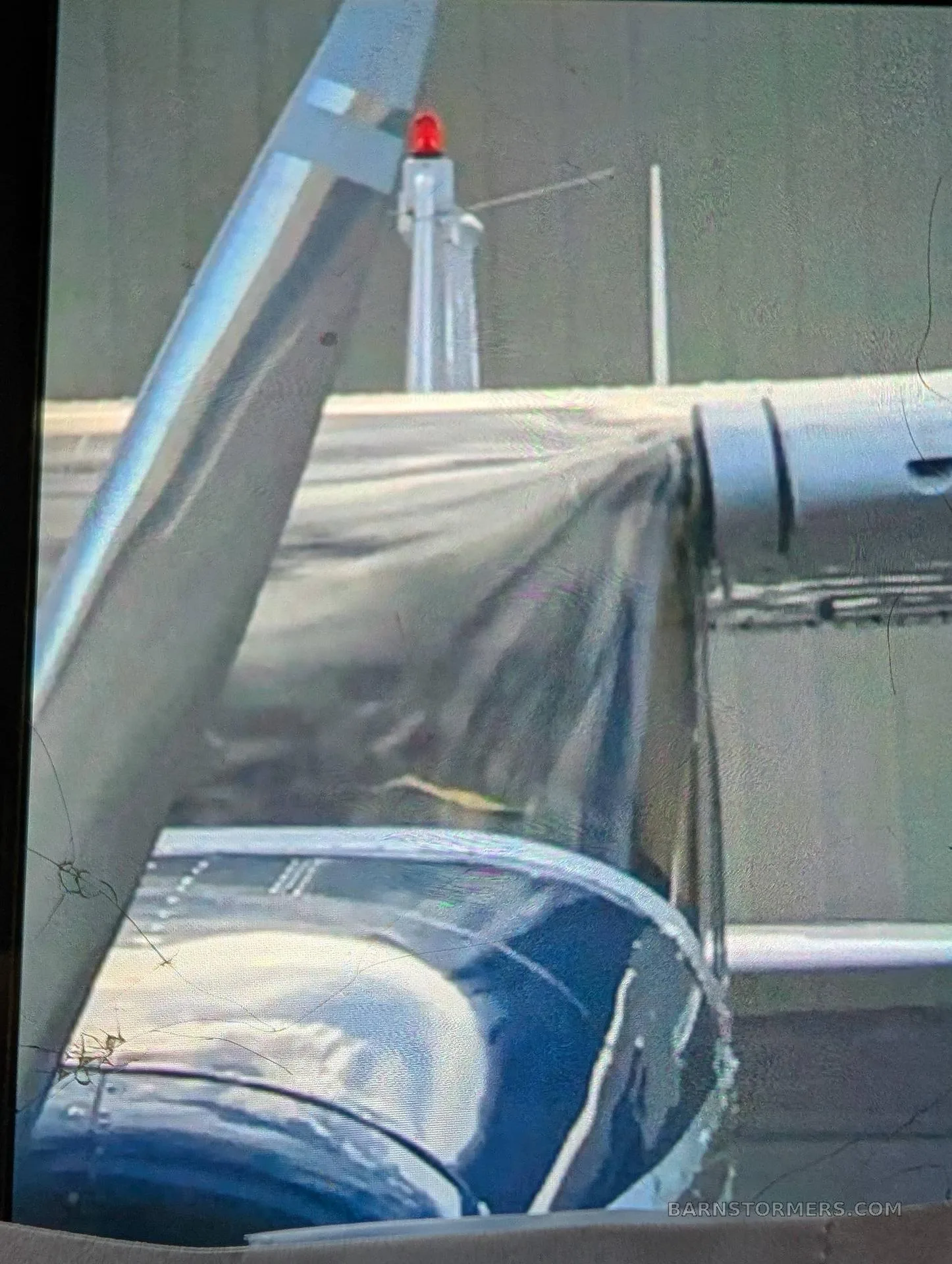A close-up view of the silver tail and blue and white fuselage of a parked aircraft.