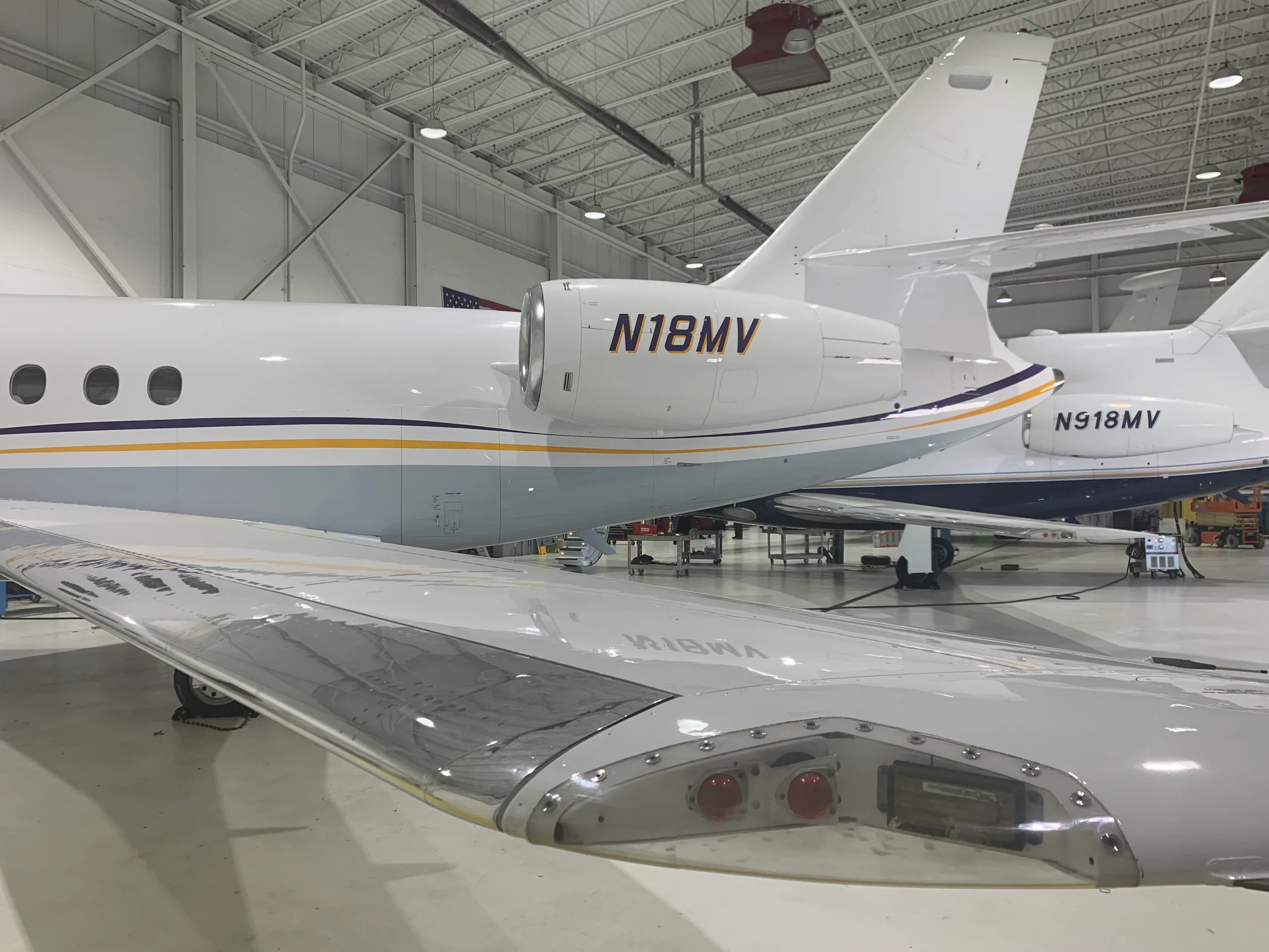 Close-up of the aircraft's engine and wing, showing the tail number N18MV.
