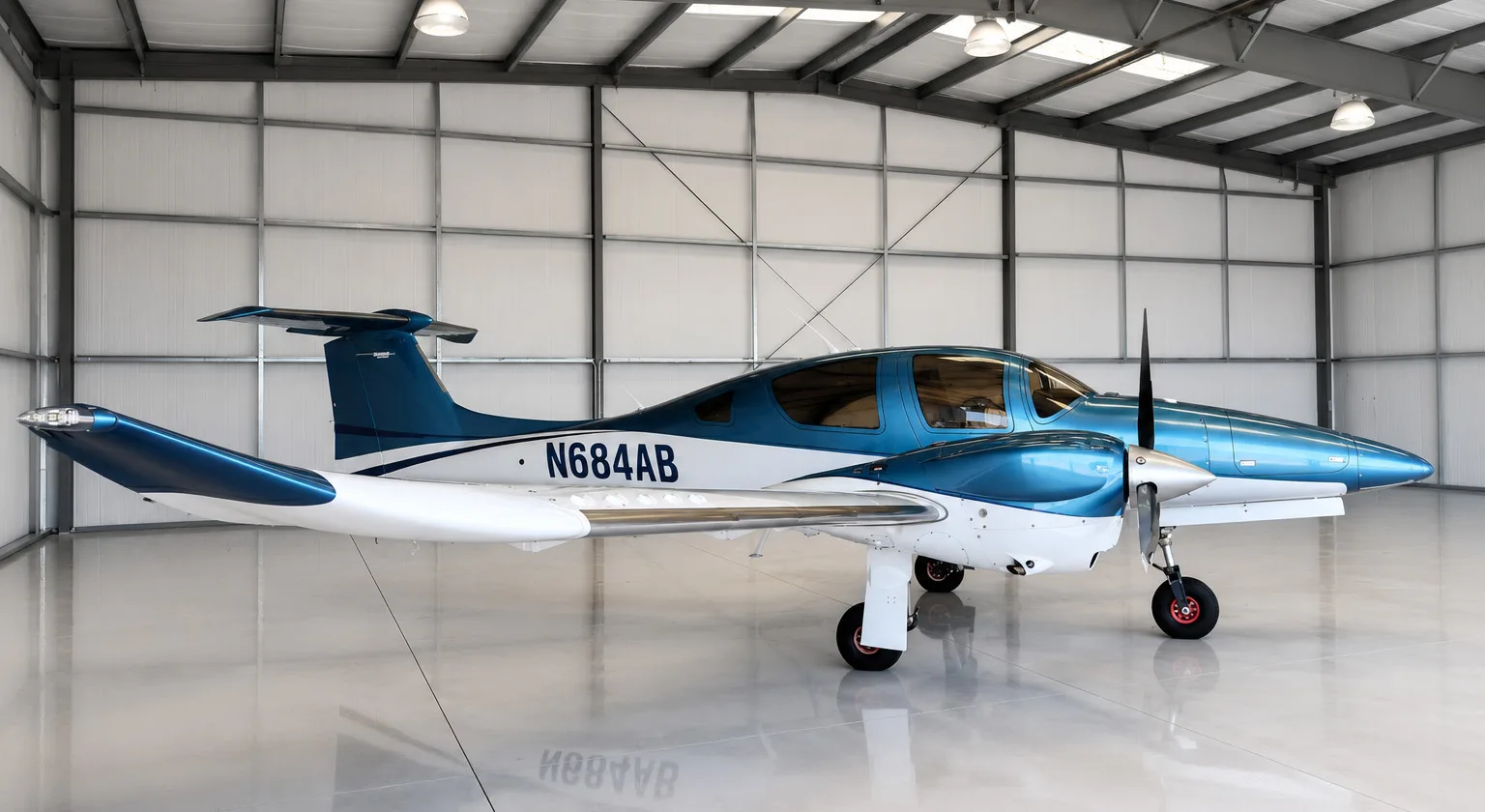 A blue and white Diamond DA62 aircraft with registration N684AB parked inside a hangar.