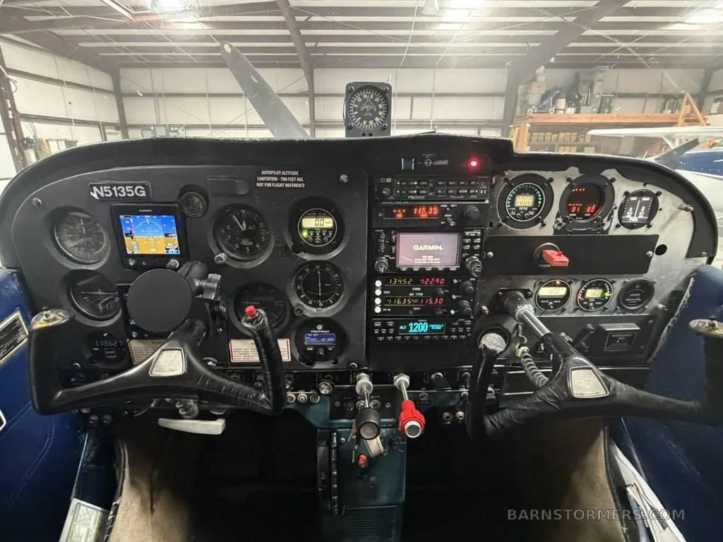 The cockpit instrument panel of a Cessna 172, featuring analog gauges and modern Garmin GPS units.