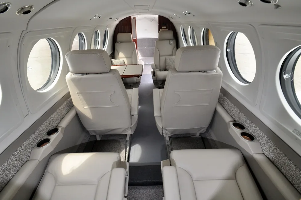 The aircraft's cabin interior with light-colored leather seats arranged in a club configuration.