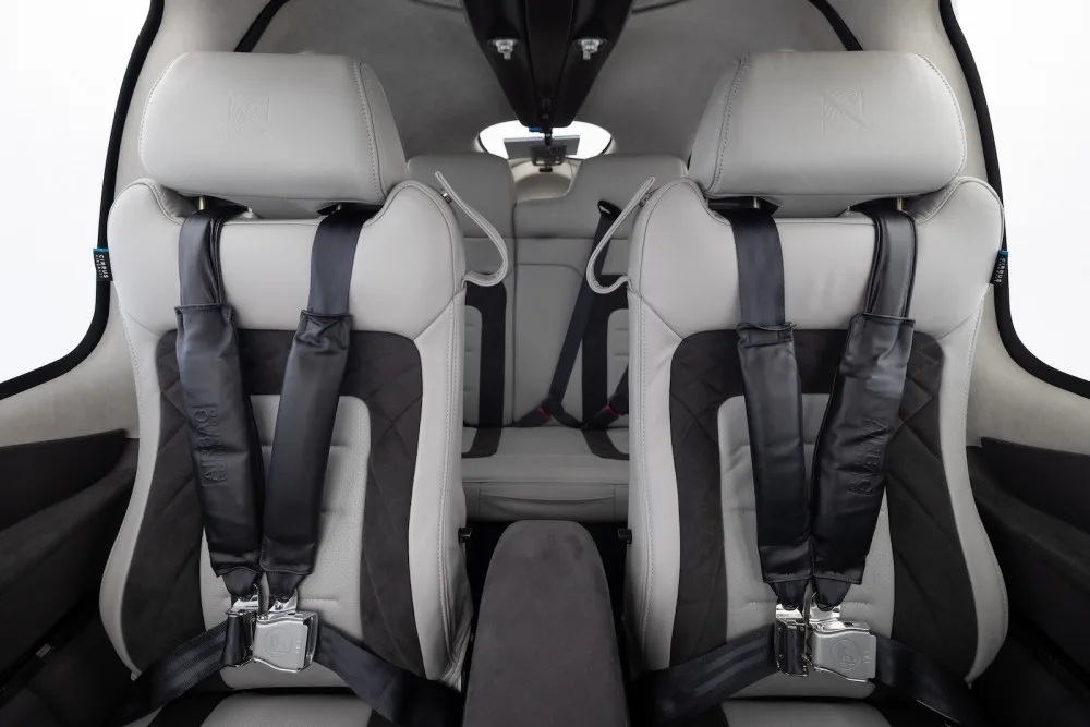 The two-tone front seats of a Cirrus SR22T aircraft cabin with seatbelts.