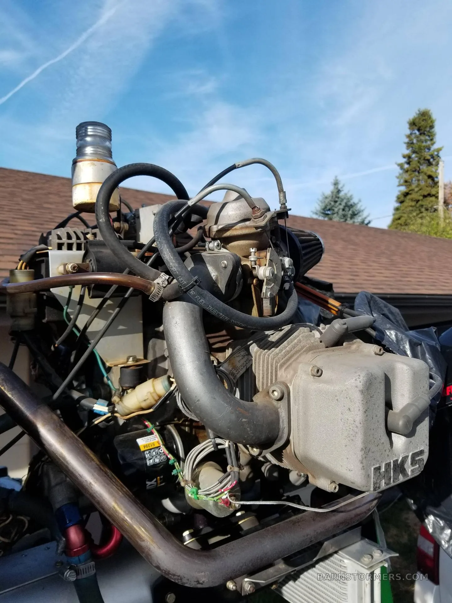 A close-up view of the HKS aircraft engine with various hoses and wires.