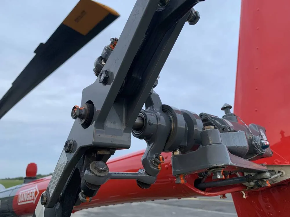 A close-up view of the red tail rotor mechanism of the Robinson R44 helicopter.