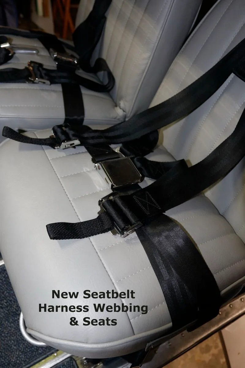 Close-up of the gray front cabin seats with new black seatbelt harnesses.