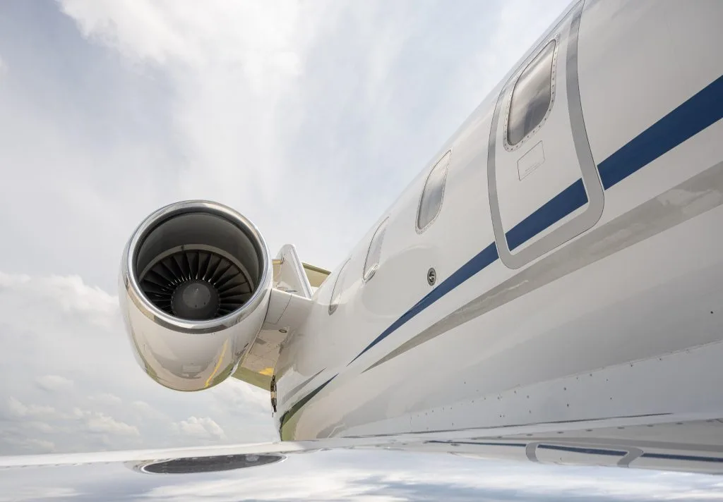 A close-up view of the front fuselage and engine of a white Bombardier Challenger jet.
