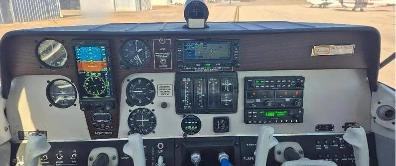 The cockpit instrument panel of a single-engine aircraft, showing various gauges, screens, and controls, with the registration N9730Q visible on the panel.