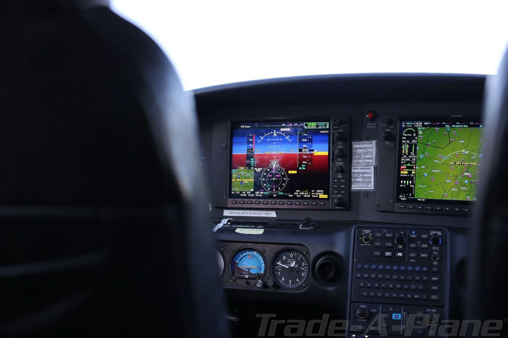 A view of the aircraft's glass cockpit from the pilot's seat, showing multiple digital displays with flight information.