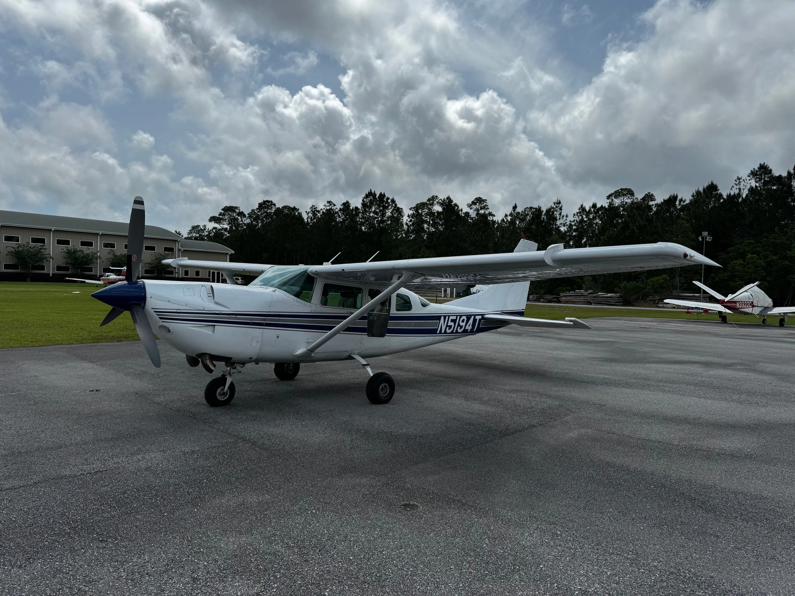 Side view of a white and blue Cessna 206 Turbo Stationair with tail number N5194T on the tarmac.