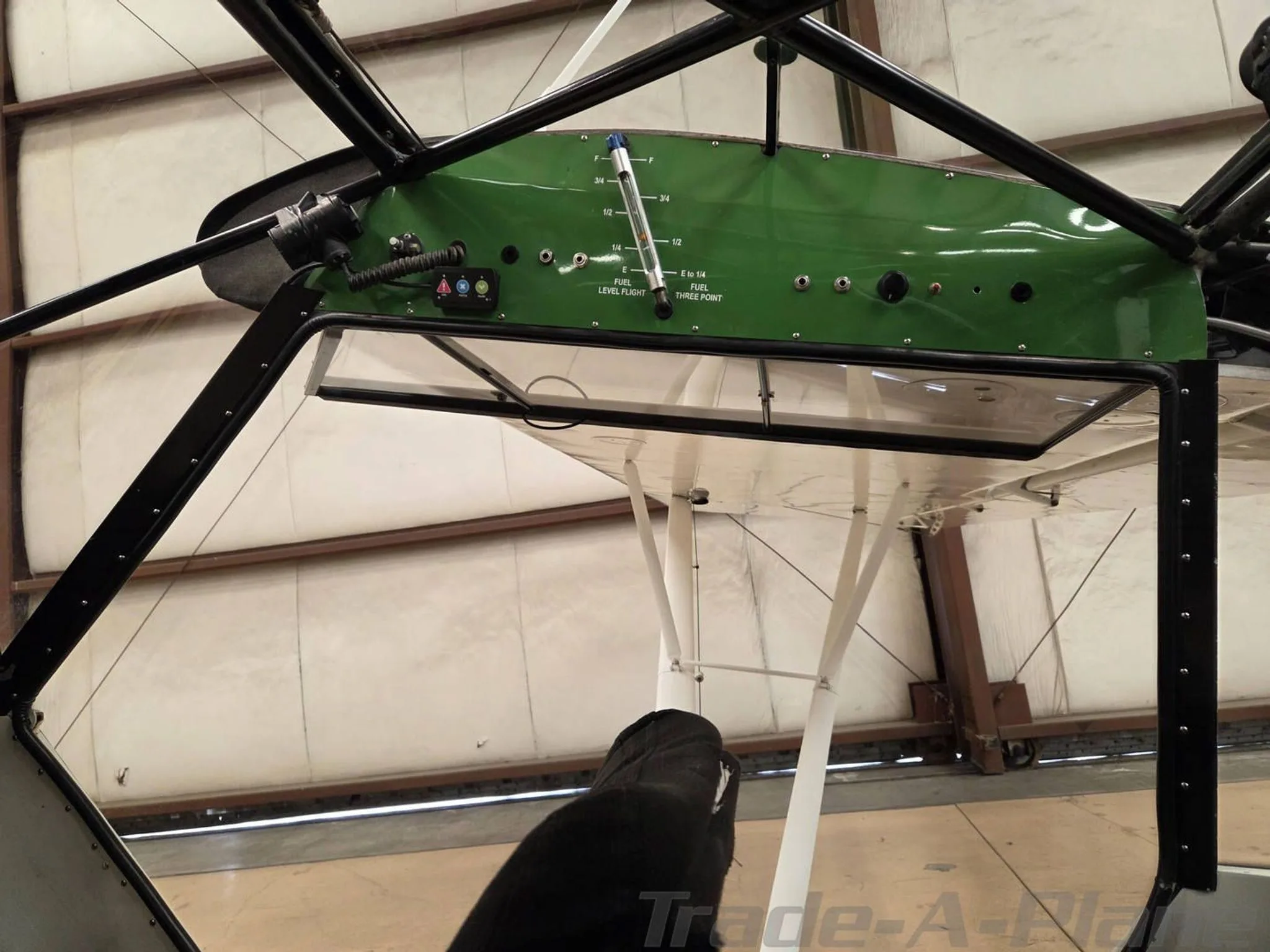 Close-up view of the green overhead panel in the Piper Super Cub cockpit, showing fuel gauges and controls.