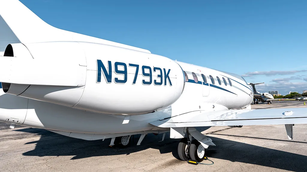 A close-up view of the rear fuselage and engine of the white business jet N9793K, showing the tail number clearly.