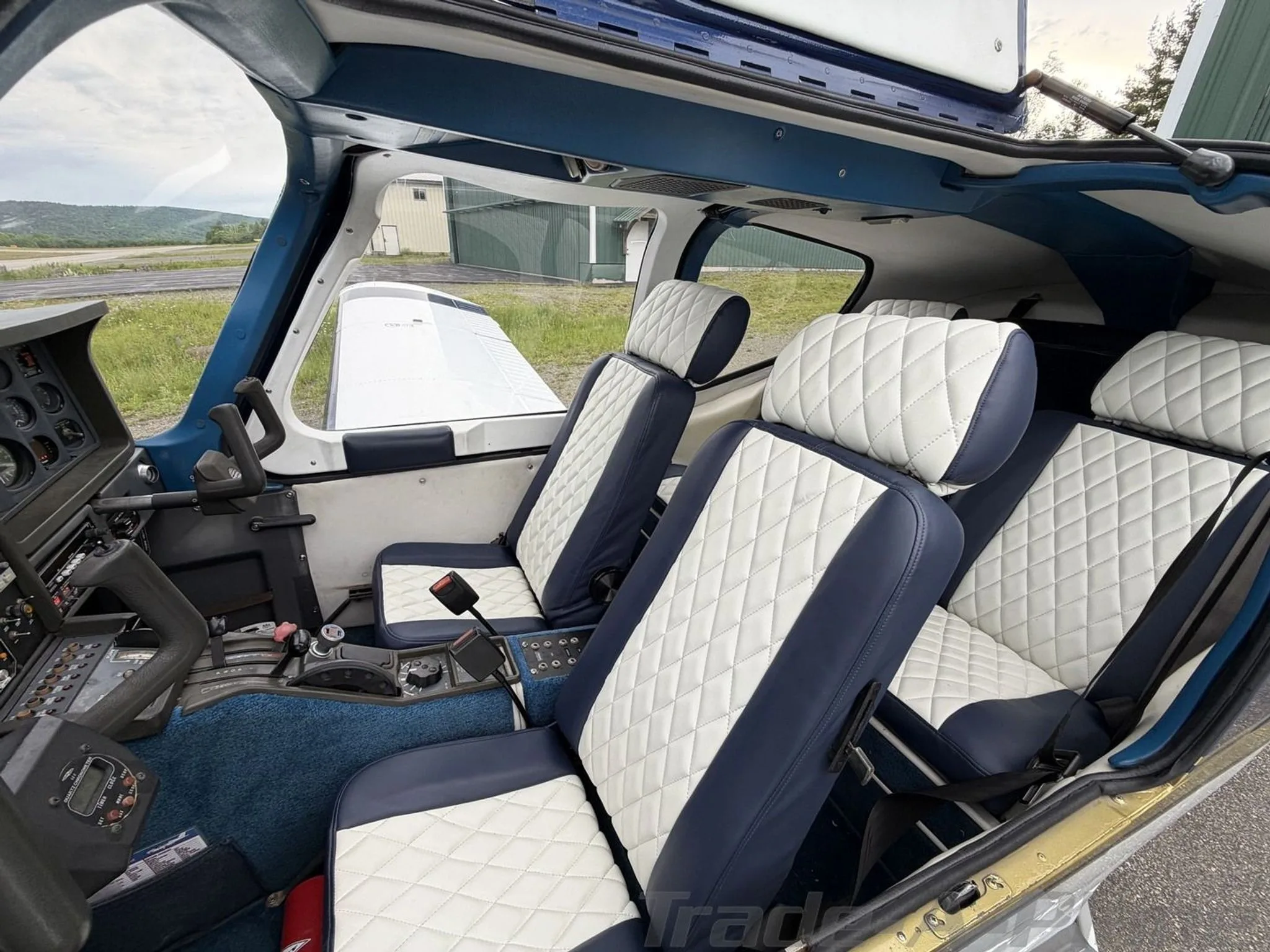 The interior cabin of the N20VC aircraft, showing blue and white quilted leather seats and blue carpet.