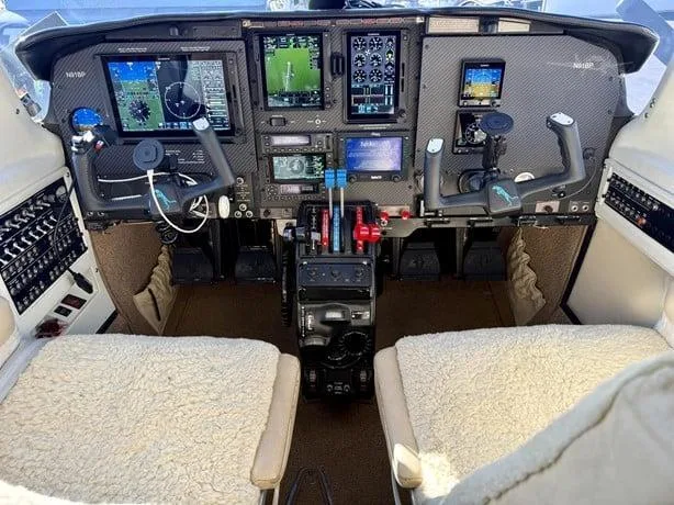 The aircraft's cockpit features a modern glass panel display with multiple screens and dual yokes.