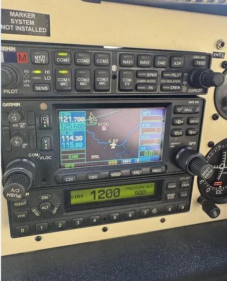 A close-up view of the Garmin avionics stack in an aircraft cockpit, showing a GPS display and a transponder set to 1200.