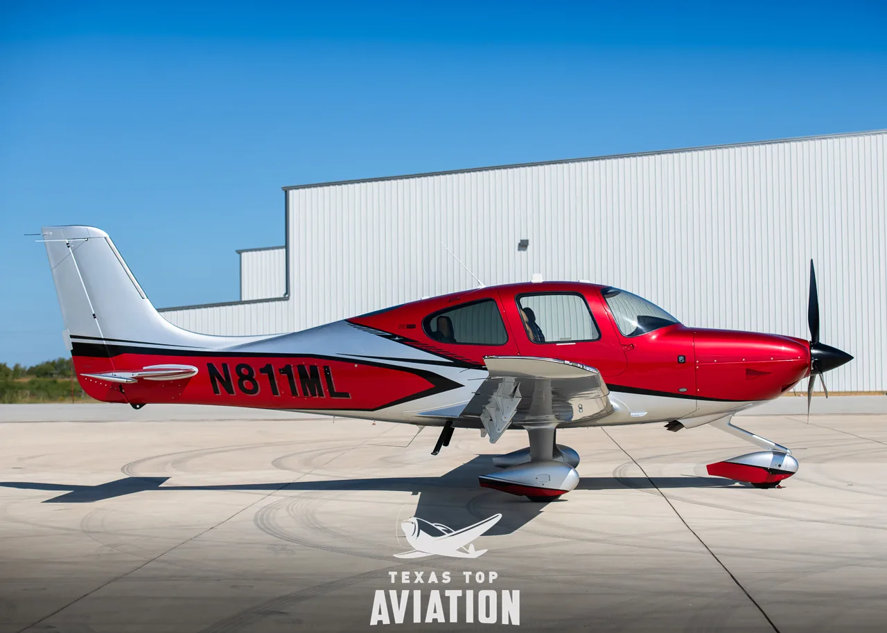A red and silver Cirrus SR22T GTS aircraft with registration N811ML parked on an tarmac.
