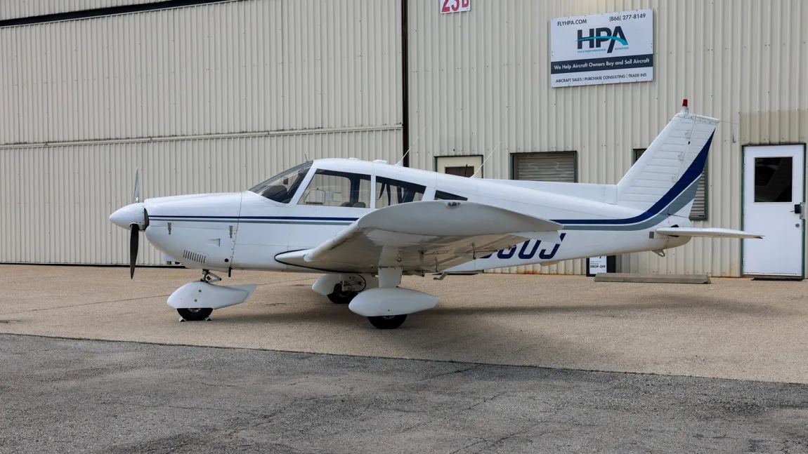 Side view of the white Piper Cherokee 180 (N9560J) showing the tail and registration number.