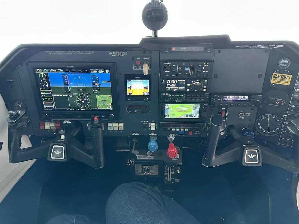A detailed view of the aircraft's modern cockpit instrument panel, featuring multiple digital displays and controls.