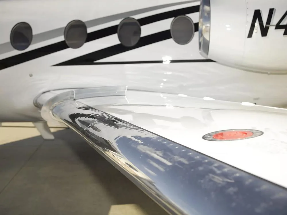 A close-up view of the wing and engine nacelle of the white Cessna Citation M2, N440LN, showing the registration.