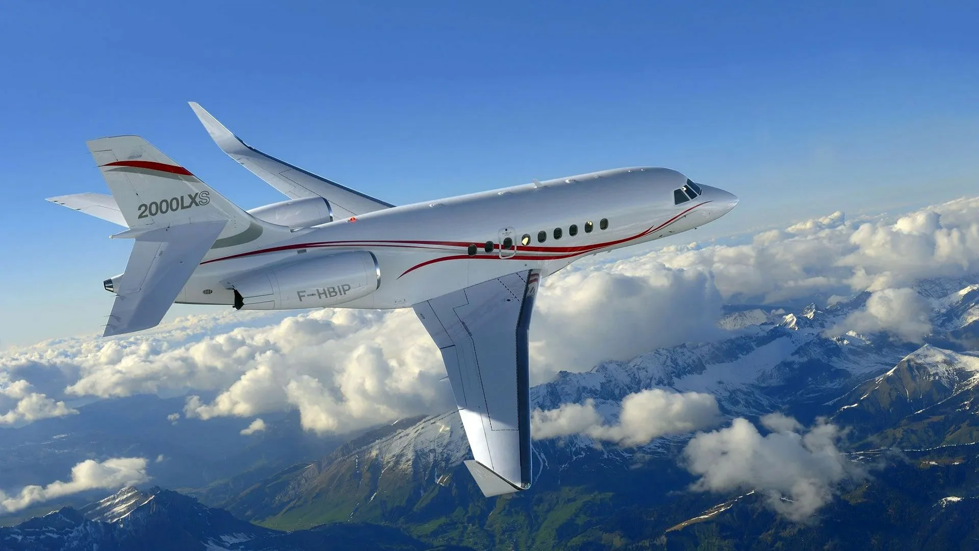 A Dassault Falcon 2000LXS flying over a mountainous landscape.
