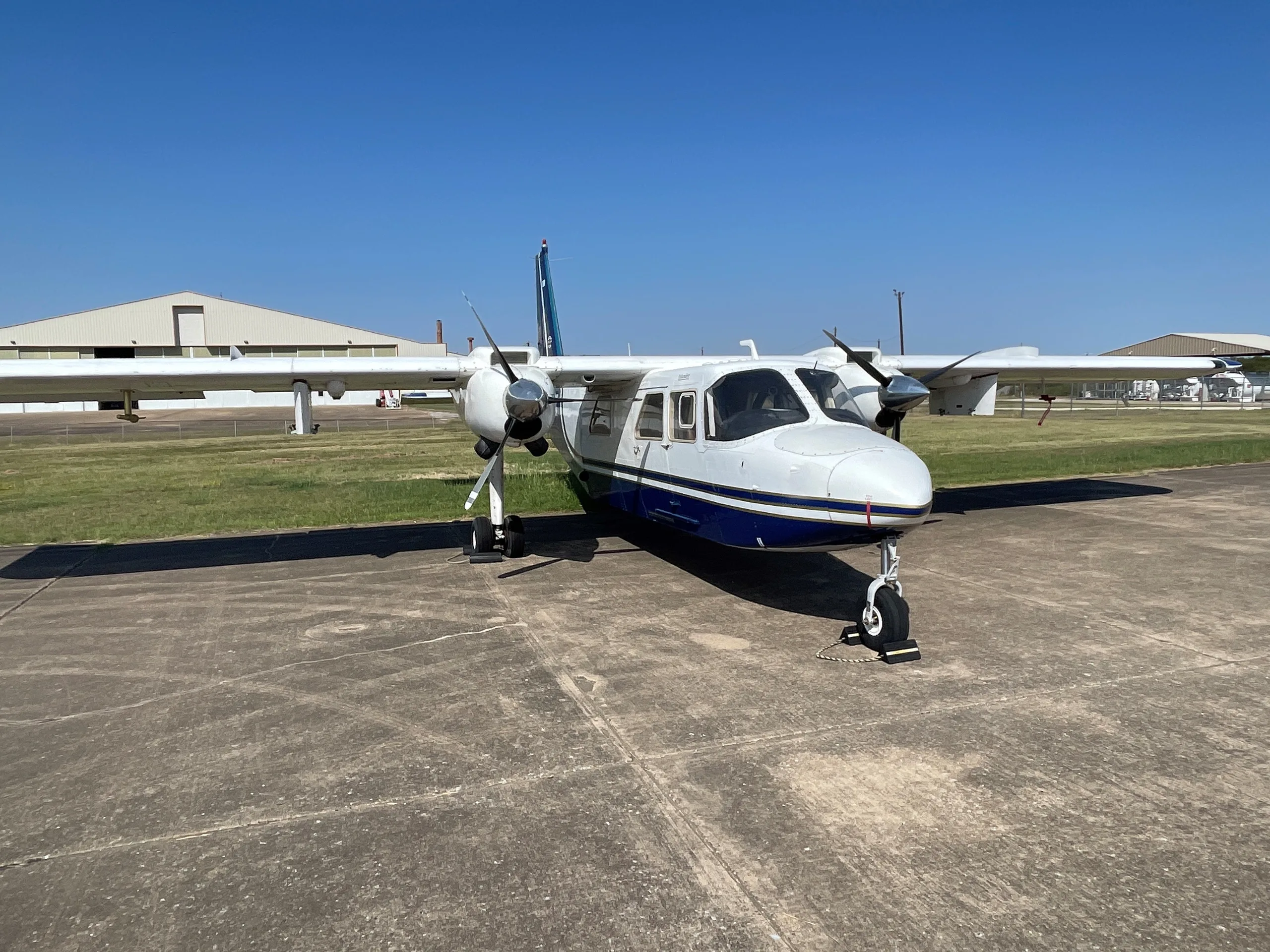 Side view of a white and blue aircraft on the tarmac.
