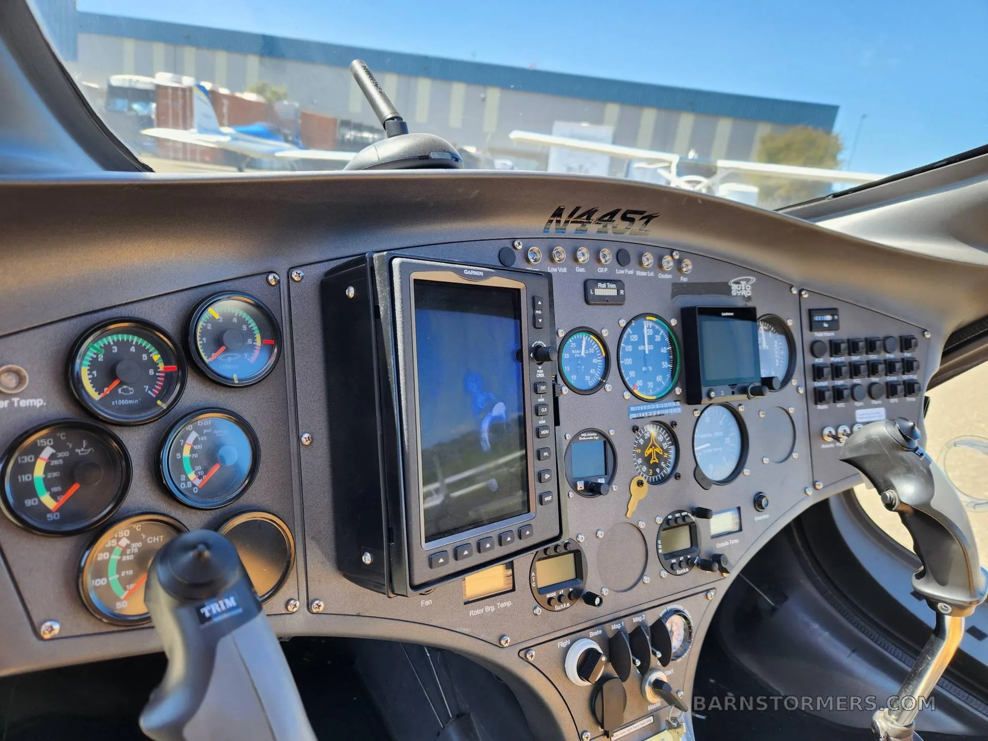 The cockpit of the gyrocopter, showing the instrument panel with multiple gauges, a central display, and controls.