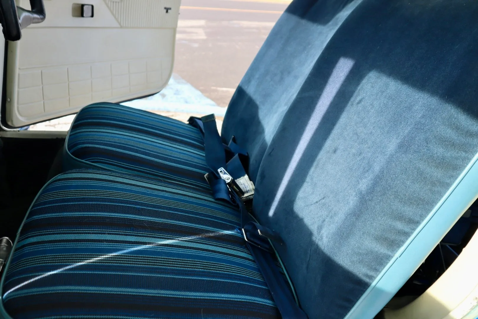 The blue striped fabric seats of a small aircraft cabin.