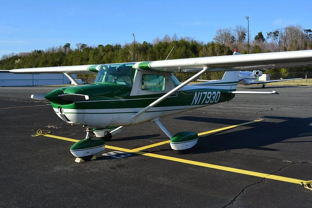 A front-quarter view of a green and white Cessna 172 aircraft, registration N1793Q, parked on an airport tarmac.