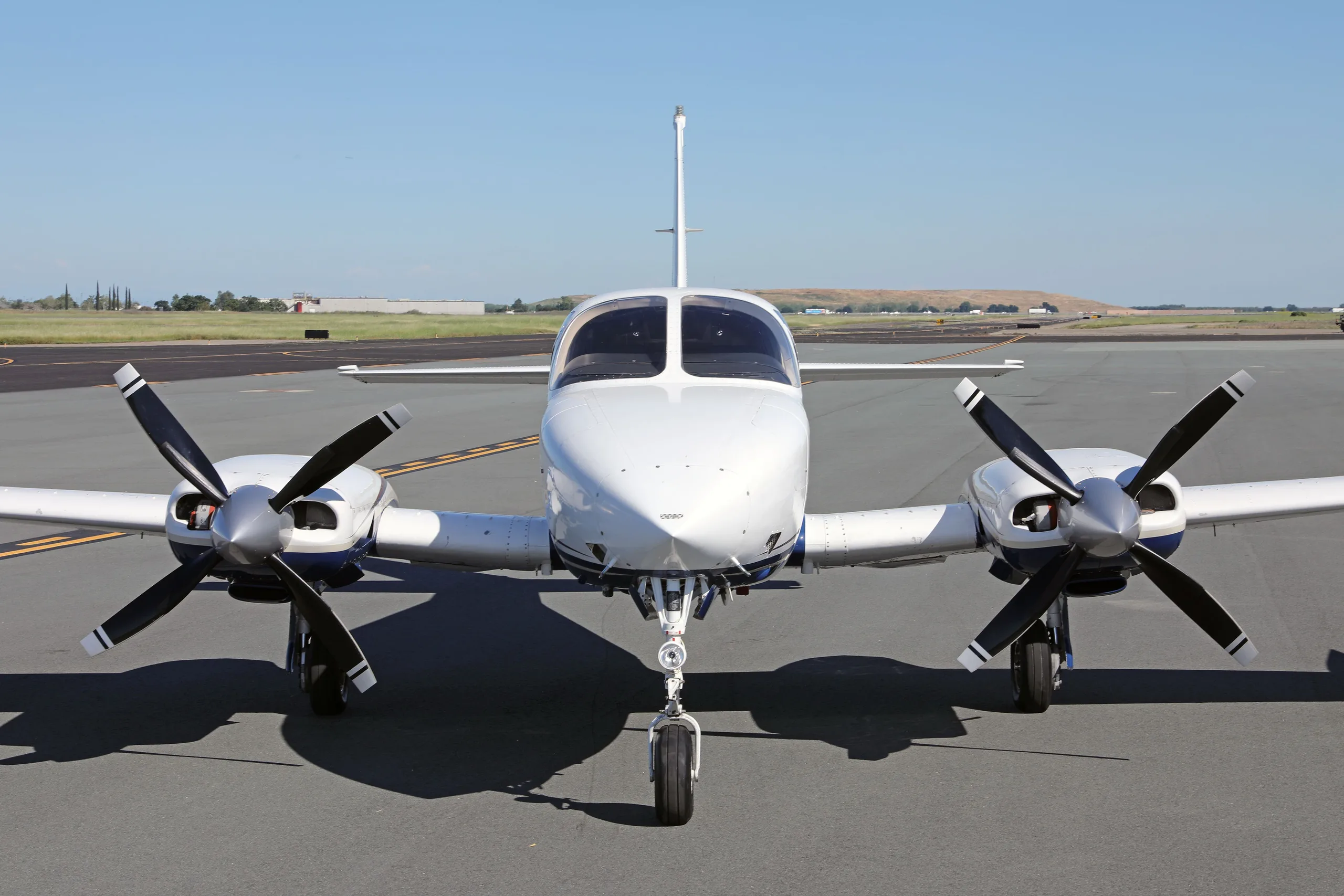 A head-on view of a white and blue Cessna 340 twin-engine aircraft with registration N340U on an airfield.