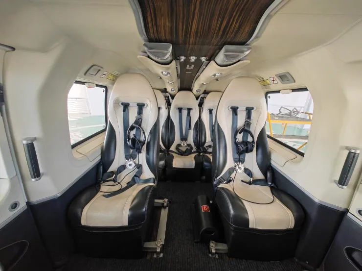 The interior of the helicopter features black and white leather seats with headsets.