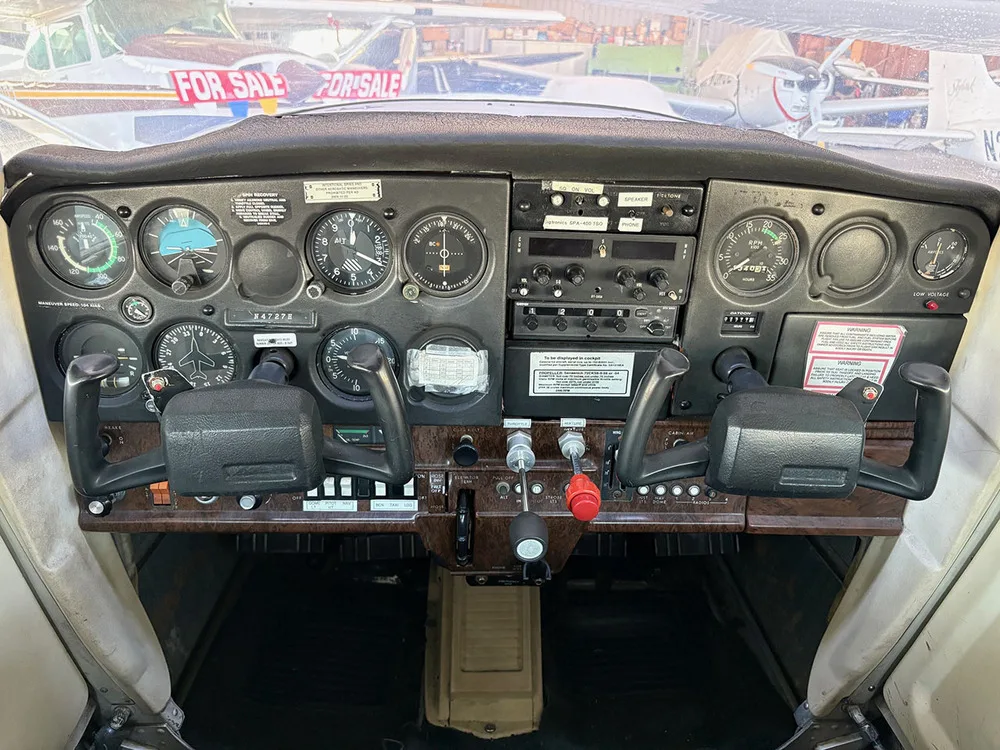 The instrument panel and yokes of a small aircraft cockpit.
