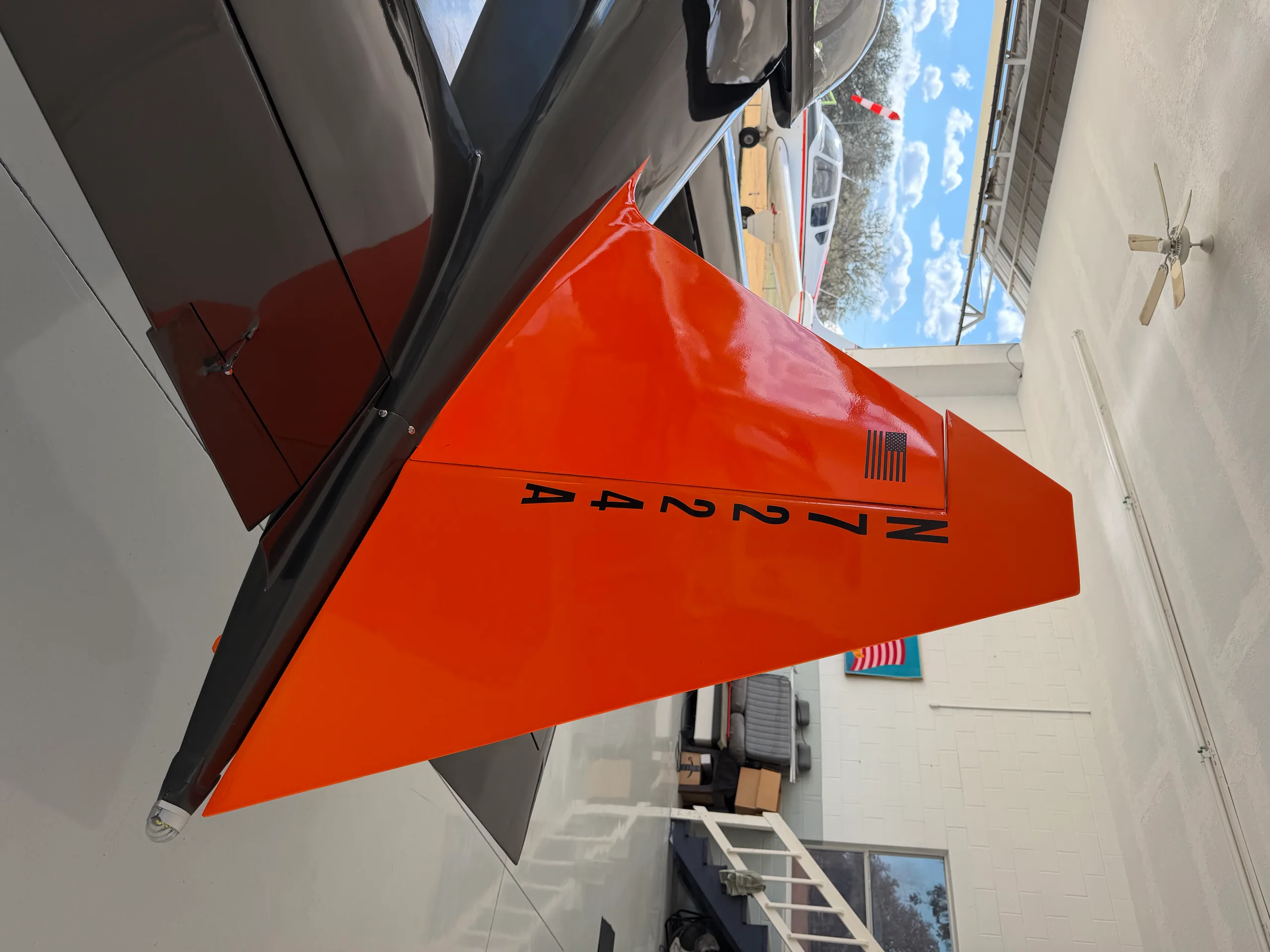 A close-up of the orange tail of the experimental aircraft, N7224A, with the registration clearly visible.