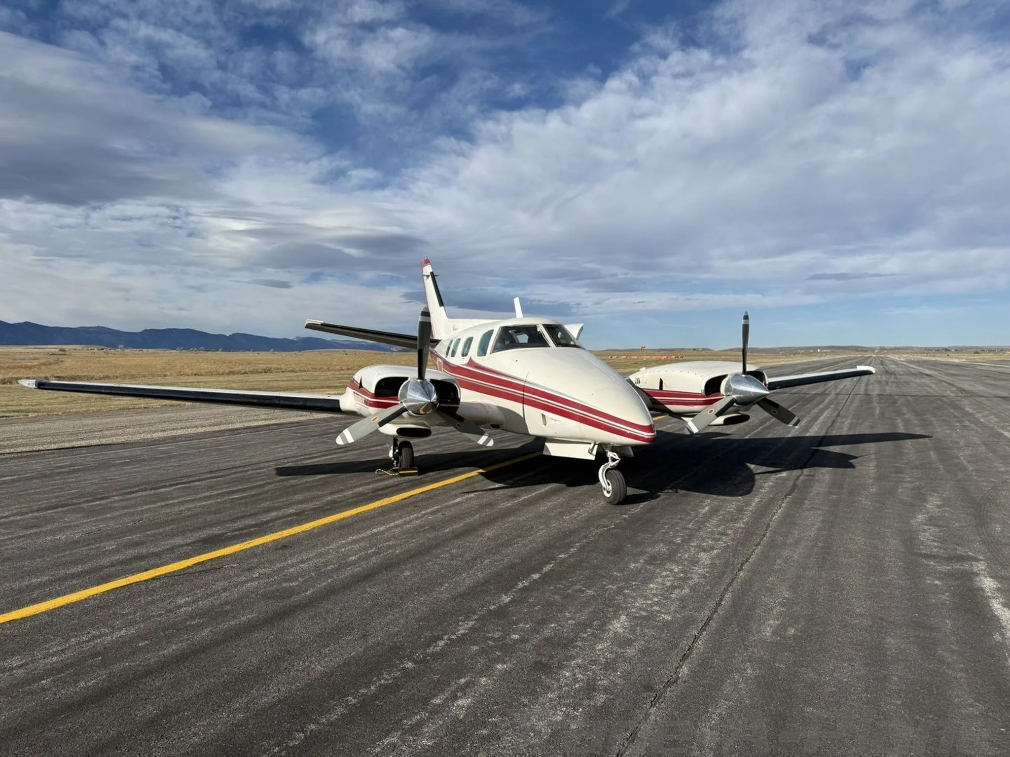 The aircraft is parked on a runway with a clear sky.