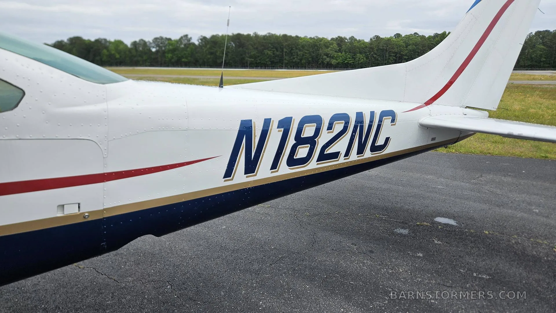 A close-up of the tail section of the Cessna 182 aircraft, showing the registration number N182NC in blue.