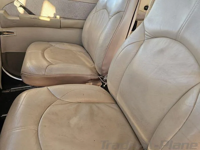 Two light tan leather aircraft seats are visible in the cabin interior.