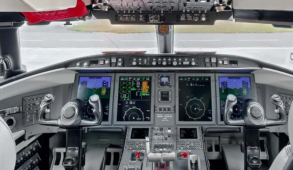 The advanced cockpit of a Bombardier Challenger business jet with multiple digital flight displays.