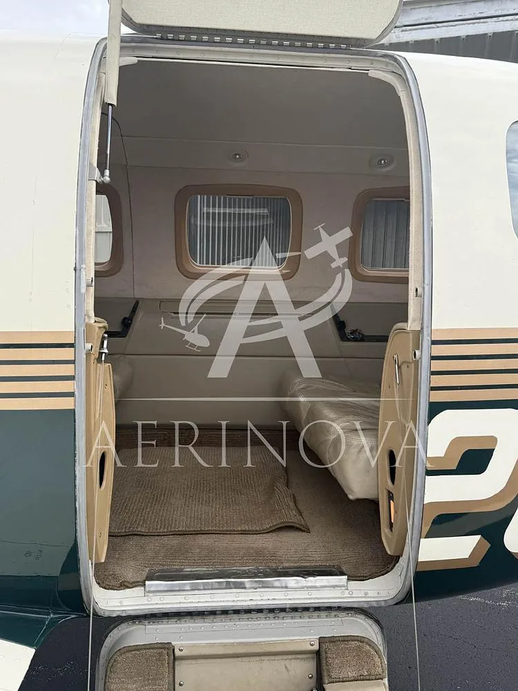 The open cabin door of the Piper Malibu Mirage N92821 revealing the light-colored interior and carpet.