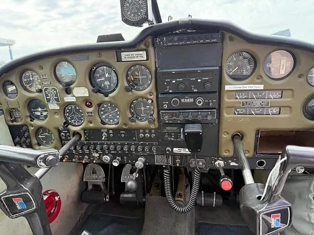 The instrument panel and controls of a small aircraft, featuring various gauges and avionics.