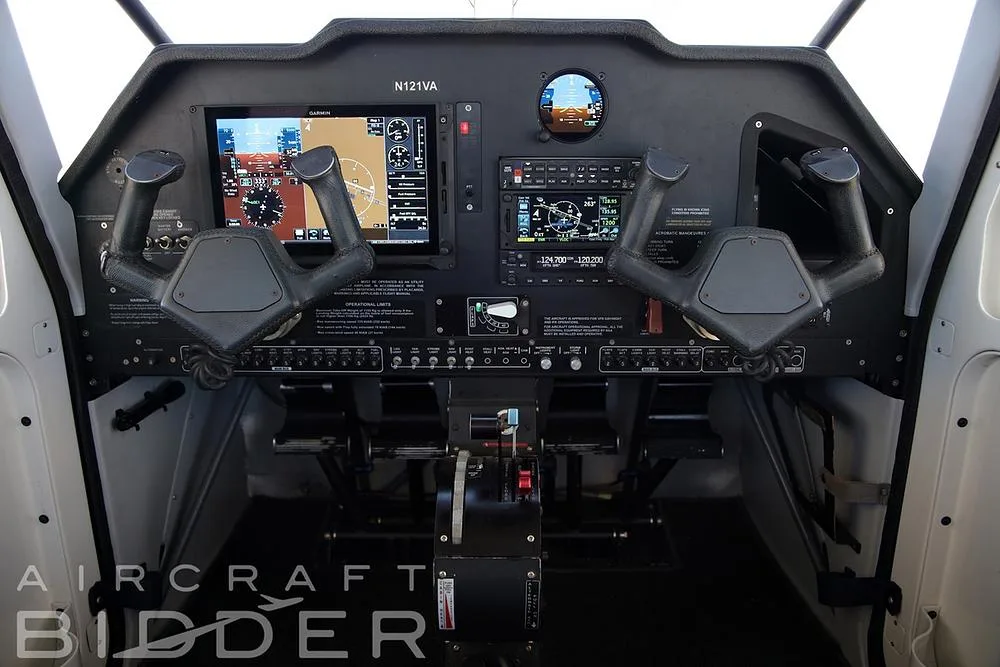 The cockpit of the N121VA Tecnam P2010, featuring a modern glass panel with two large displays and dual yokes.