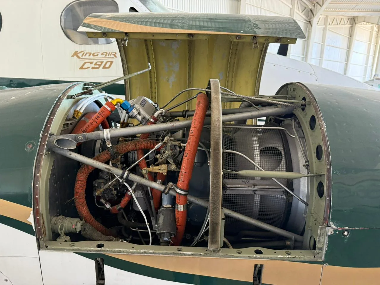 Open engine cowling revealing the turboprop engine and internal components of a King Air C90.