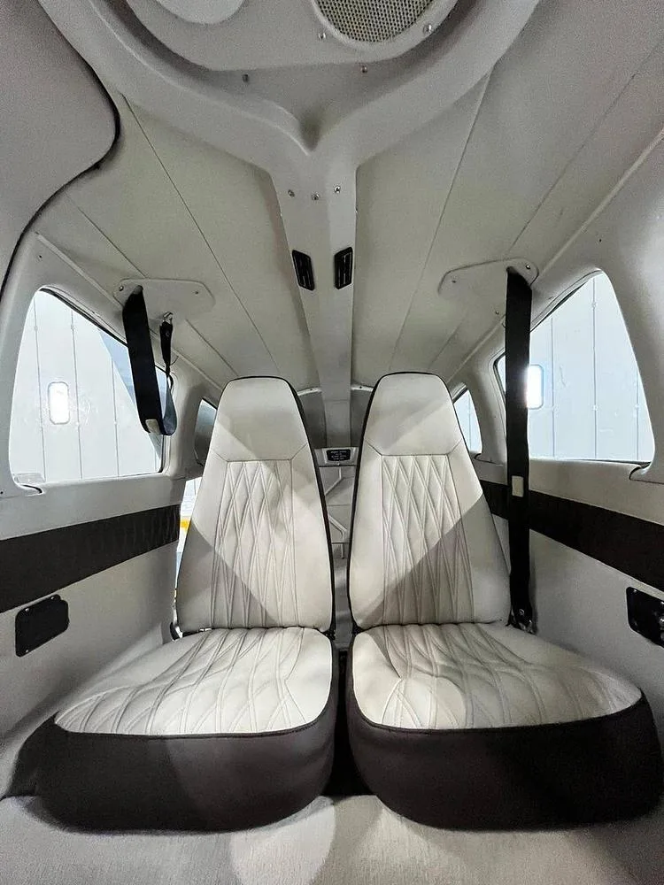 The aircraft's rear cabin with two light-colored, quilted seats.
