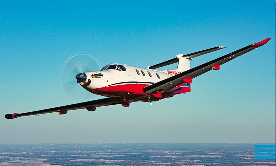 Pilatus PC-12 aircraft N641KC in flight with a red and white paint scheme.